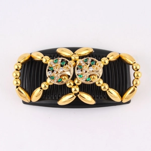 Close-up of double hair comb with tree of life design and green rhinestones detail