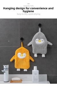 Detail of hanging penguin hand towels showing soft microfiber texture and hooks