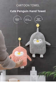 Detail of penguin-shaped coral fleece hand towels in pink and gray on bathroom tiles