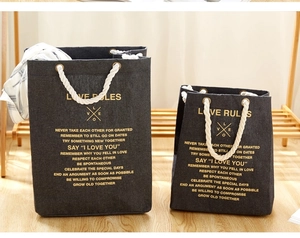 Detail of grey cotton rope storage bags with golden 'Love Rules' typography print