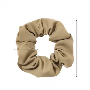 Detailed view of khaki plaid scrunchie with 11cm diameter and cotton fabric texture