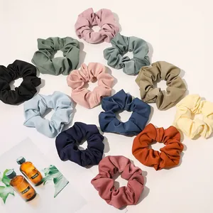 Detail showing various colors of plaid fabric scrunchies with soft pleated texture