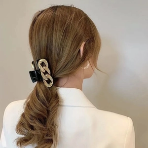 Vintage pearl hair claw clip with gold chain detail on model's ponytail hair