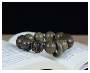 Vue macro de perles en santal vert avec sculpture de dragon et grain de bois naturel