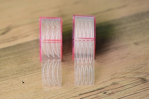 Lace double eyelid tape in crescent and olive shapes on wooden background