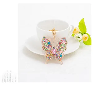 Detail of butterfly keychain with colorful rhinestones on a white ceramic cup