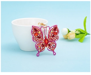 Detail of red butterfly keychain with sparkling crystals and golden metal chain link