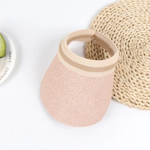 Detailed macro view of children pink straw sun hat with striped elastic headband