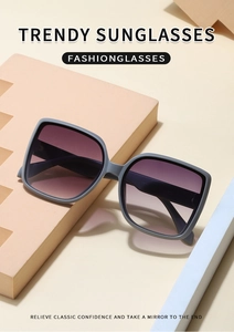Detail view of square matte grey sunglasses with purple gradient lenses on geometric props