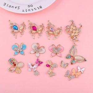 Flat lay of colorful alloy butterfly charms with rhinestones and opal for DIY crafts