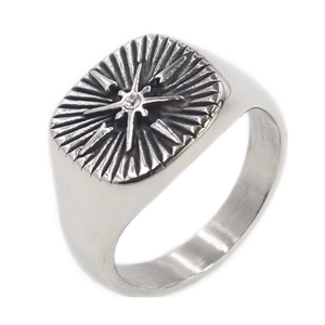 Macro shot of silver stainless steel signet ring with North Star relief and zircon