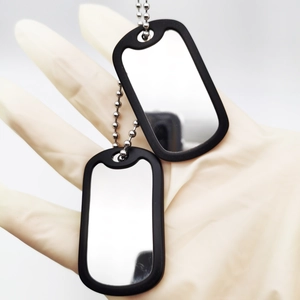 Detail of silver stainless steel military dog tags with black silicone silencers on bead chain