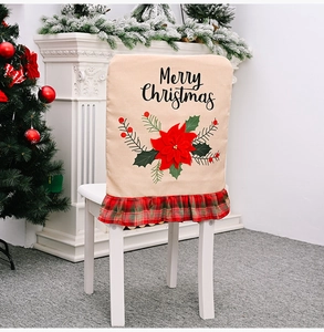 Detail of burlap Christmas chair cover with Merry Christmas text and red poinsettia flower