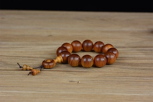 Macro shot of 12 large Thuja wood beads showing natural reddish brown grain patterns