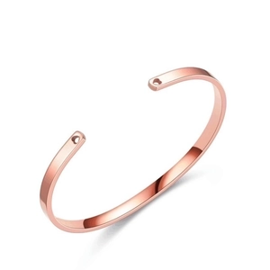 Detailed view of a rose gold stainless steel C-shaped open bracelet on a clean white background