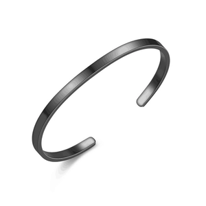 Detailed close-up of a smooth black titanium steel C-shaped open cuff bracelet