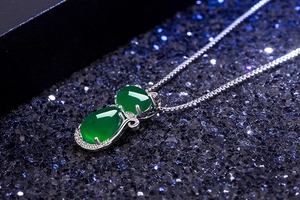 Macro side view of green agate cat pendant with silver plating and micro-inlaid diamonds