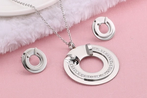 Detailed view of silver stainless steel jewelry set with hollow round design and crystals