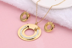 Detailed view of gold plated titanium necklace and earrings set with hollow diamond accents