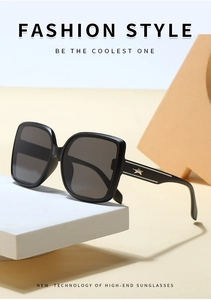 Detail of square black sunglasses featuring gold star metal accents on streamlined temples
