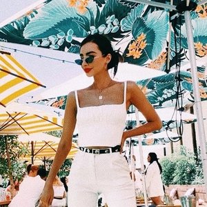 Detailaufnahme von weißem plissiertem Trägertop und passender High-Waist-Hose im Freien