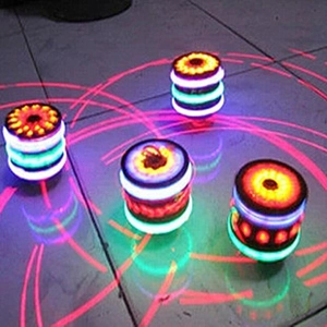 Dettaglio di trottole LED colorate con anelli luminosi dinamici su pavimento