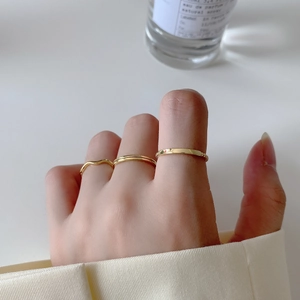 Detailed view of three minimalist gold rings set styled for elegant daily wear