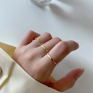 Close-up of three gold minimalist 925 silver rings worn together on fingers