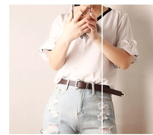 Detail of vintage dark brown leather belt with silver buckle on light blue jeans