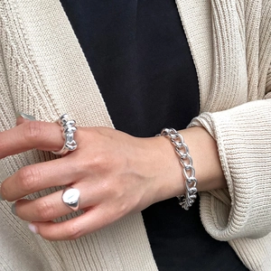 Detail of 925 sterling silver spring ring and cuban chain bracelet on a model