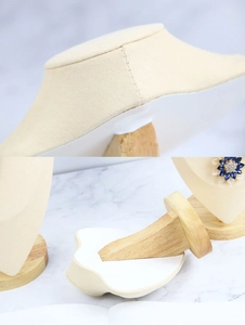Detail of beech wood necklace display stand with beige velvet finish and solid wood base