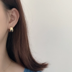 Close-up of minimalist gold-plated S925 silver wide hoop earring worn by a model