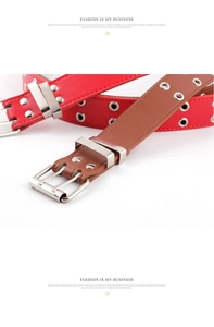 Close-up of punk style PU leather belts with double row eyelets and silver prong buckles
