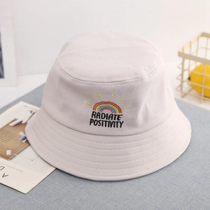Detail of rainbow embroidery and RADIATE POSITIVITY text on cotton sun hat