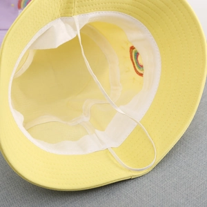 Detail of yellow kids bucket hat showing white sweatband and elastic windproof strap