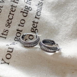 Macro detail of S925 sterling silver vintage earrings with woven texture and oxidized finish