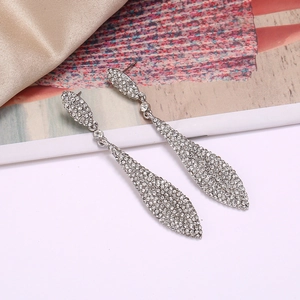 Detail of luxury teardrop silver earrings with micro-paved crystals on fashion magazine