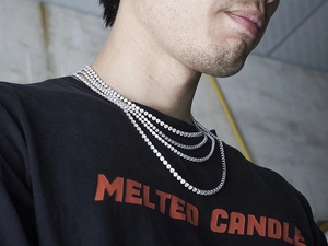 Close-up of layered silver iced out tennis necklaces on neck with sparkling rhinestones