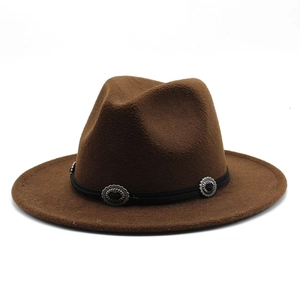 Détail d'un chapeau fedora marron foncé avec bande noire et boucles en métal vintage