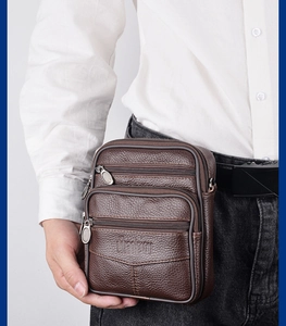 Close-up of brown textured leather waist bag featuring multiple zipper compartments