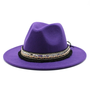 Detail of purple fedora hat featuring a decorative sequin band and ethnic fringe trim