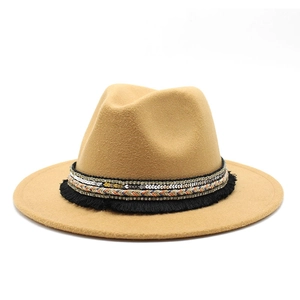 Close-up of a camel wool fedora hat featuring a decorative tassel and sequined band