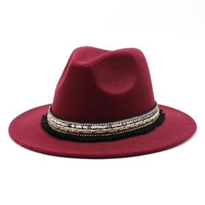 Detail of burgundy fedora hat with ethnic style sequin band and black tassel trim