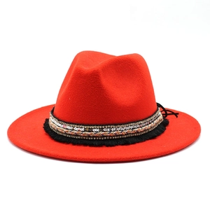 Close-up of red wide brim fedora hat featuring ethnic ribbon with sequins and tassels