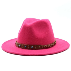 Detail of deep pink fedora hat featuring woven leather band with studs and blue beads