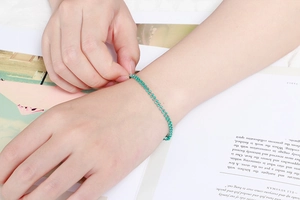 Détail d'un bracelet bohème fait main en acier inoxydable avec pierres vertes au poignet
