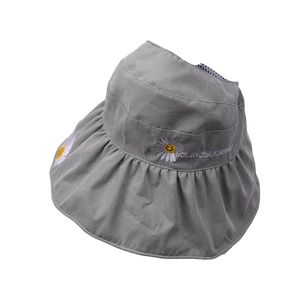 Detail of gray sun hat featuring daisy flower embroidery and black white checkered lining