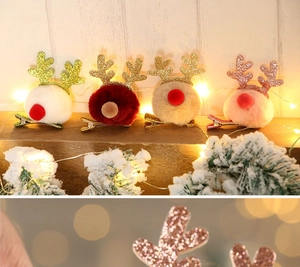 Close-up of glitter reindeer antler hair clips with plush pompoms in festive Christmas setup