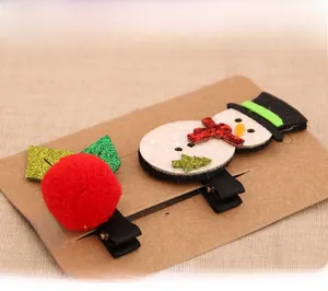 Detail of Christmas snowman and red pompom hair clips on brown display card