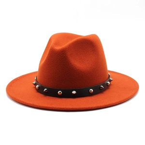 Detailed macro view of orange wool fedora hat with silver punk rivets on leather band